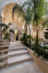 a courtyard with palm trees and stairs in a building at Melisende in Acre