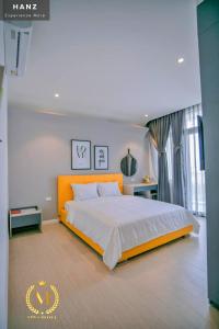 a bedroom with a large bed with an orange headboard at HANZ Mina Hotel in Ấp Long Khánh