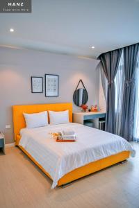 a bedroom with an orange bed and a desk at HANZ Mina Hotel in Ấp Long Khánh