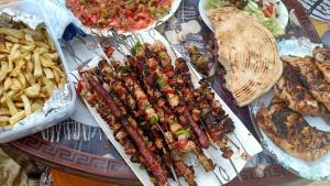 a table with many different types of food and french fries at Panorama Camp Bidiya in Al Wāşil