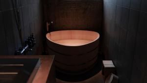 e bagno con vasca e lavandino. di deigo ISHIGAKI ｜沖縄石垣島の一棟貸し別荘［泥娯］ a Isola di Ishigaki