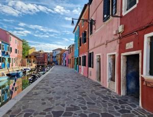 a street with colorful buildings next to a canal at Ca' Nova - Burano in Burano