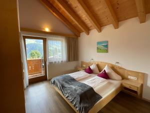 a bedroom with a bed and a large window at Appartements Am Burgsee in Ladis