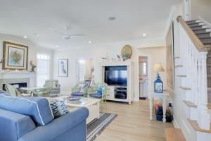 sala de estar con sofá azul y TV en Sirens Call Ocean Ridge, en North Topsail Beach