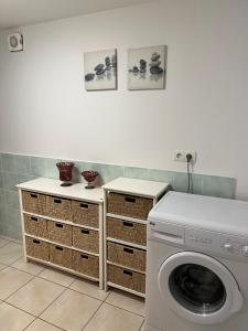 a laundry room with a washing machine and baskets at Lou Souleu in Riez