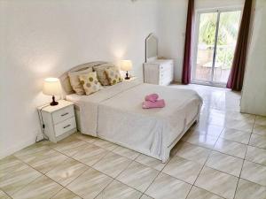 a bedroom with a bed with a pink hat on it at Maison à proximité de la plage - LE TAMIER - Flic en Flac in Flic-en-Flac +16 photos