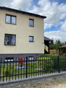 une clôture noire devant une maison dans l'établissement Dziewięciu z nieba 9, à Kaliska
