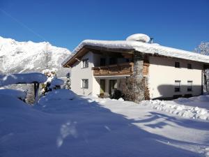 a snow covered house with a snow covered roof at Appartements Anfang in Weerberg