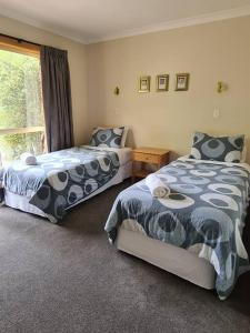 una camera da letto con due letti e una finestra di REDGUM RETREAT BRIGHT - Luxury Spa Villa a Bright