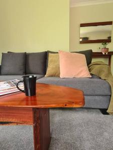 a living room with a couch and a coffee table at REDGUM RETREAT BRIGHT - Luxury Spa Villa in Bright