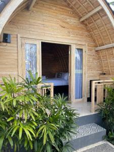 Habitación con cama en una casa de madera en Mulia Manise The Bahari Villas Bali en Pacung