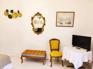 a room with a table and a tv and a chair at Chambres d'hôtes du domaine de l'Isle in Civray-de-Touraine