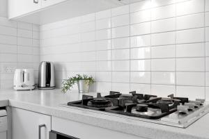 a kitchen with a stove top in a white kitchen at Burwood Newly Renovated 2 Bedroom Apartment in Sydney
