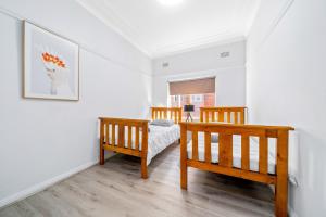 a bedroom with two beds and a picture on the wall at Burwood Newly Renovated 2 Bedroom Apartment in Sydney
