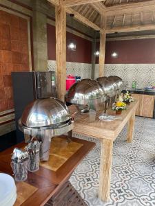 una cocina con 4 cuencos de cobre sobre una mesa de madera en Mulia Manise The Bahari Villas Bali en Pacung
