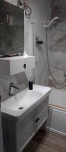 a bathroom with a white sink and a shower at Sweet Home in Dakar
