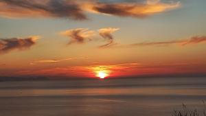 a sunset over the ocean with clouds in the sky at Villa Verde in Cefalù