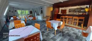 a dining room with tables and chairs and a kitchen at Penzion Svojanov in Svojanov