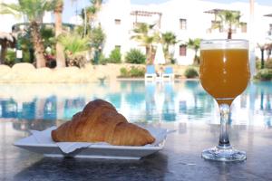 a plate of bread and a glass of orange juice at Herrmes Hospitality in Sharm El Sheikh