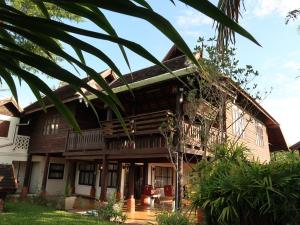 uma casa com uma palmeira em frente em Chiangmai Lanna em San Kamphaeng