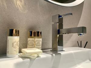 a bathroom sink with a faucet and two bottles of soap at Ribeira House in Mirandela