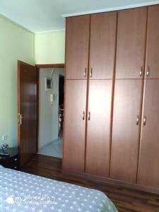 Schlafzimmer mit Holzschränken und einem Bett in der Unterkunft Квартира в центре города-курорта рядом с пляжем in Loutraki
