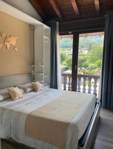 um quarto com uma cama grande e uma janela grande em La terrazza sulle vigne B&B em Corte Franca