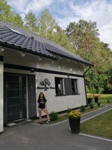 Cierzpięty的住宿－Mazurska Niwa，站在小建筑外的妇女