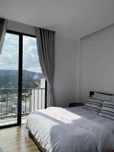 a bedroom with a bed and a large window at Dalat Topview Homestay in Da Lat