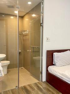 a bathroom with a shower and a bed and a toilet at Dalat Topview Homestay in Da Lat
