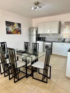 a dining room with a glass table and chairs at Stunning Spacious 2-Bed Apartment in Liopetri in Liopetri