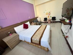 馬公市的住宿－幸福陽光民宿，一间卧室配有一张大床和紫色墙壁