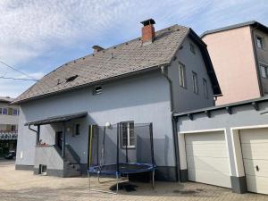 une maison avec une table bleue devant elle dans l'établissement Appartement Wörthersee, à Klagenfurt am Wörthersee