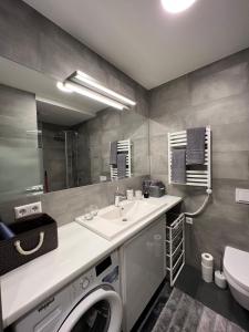 a bathroom with a sink and a washing machine at Cosy 1 bedroom apartment in the heart of old town with parking in Kaunas