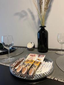 a table with a plate with wine glasses and a vase at Cosy 1 bedroom apartment in the heart of old town with parking in Kaunas