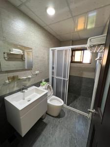 馬公市的住宿－幸福陽光民宿，浴室配有卫生间、盥洗盆和淋浴。