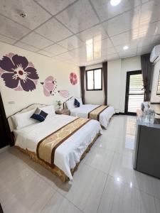 馬公市的住宿－幸福陽光民宿，墙上花房的两张床