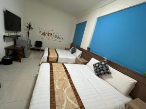 馬公市的住宿－幸福陽光民宿，酒店客房设有两张床和电视。