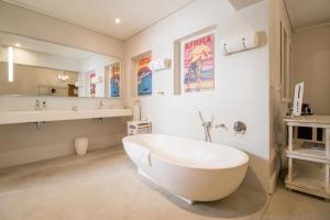 ein Badezimmer mit einer Badewanne und einem Waschbecken in der Unterkunft Harbour House Hotel - Adventure Pads in Hermanus
