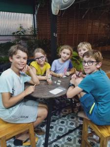 un grupo de niños sentados en una mesa en Siri Guesthouse en Phra Nakhon Si Ayutthaya