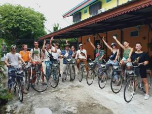 Un groupe de personnes sur des vélos posant une photo dans l'établissement Siri Guesthouse, à Phra Nakhon Si Ayutthaya