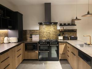 a kitchen with wooden cabinets and a black stove top oven at Black Stilt Retreat, STUNNING luxury property in Twizel +13 photos