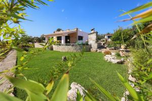 Un jardín con una casa al fondo en Tenuta Ferilli, en Salve