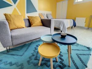 - un salon avec deux tables et un canapé dans l'établissement SUPERBE STUDIO HYPER CENTRE TOUT ÉQUIPÉ WIFI NETFLIX 2PERS, à Amiens
