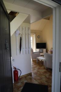 un soggiorno con mobili bianchi e una porta aperta di Bergh & Duin - lakens, elektriciteit en water inbegrepen a De Panne