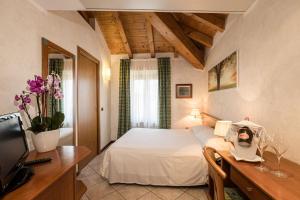 sypialnia z łóżkiem, biurkiem i telewizorem w obiekcie Hotel Corte Regina w Sirmione +37 zdjęć