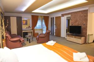 a hotel room with a bed and a television at Hotel Rothmans in Bansko