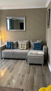 a living room with a couch and a mirror at Cheerful 3 bedroom Townhouse with free parking. in Billericay