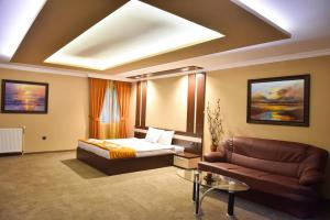 ein Hotelzimmer mit einem Bett und einem Sofa in der Unterkunft Hotel Rothmans in Bansko