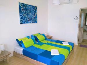 a bedroom with a bed with blue and green at Ten RooMs in Telukbakau